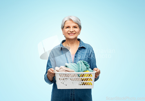 Image of smiling senior woman with laundry basket