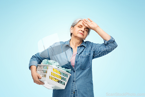 Image of tired senior woman with laundry basket