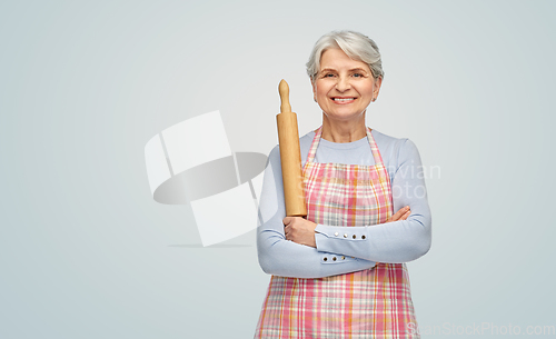 Image of smiling senior woman in apron with rolling pin