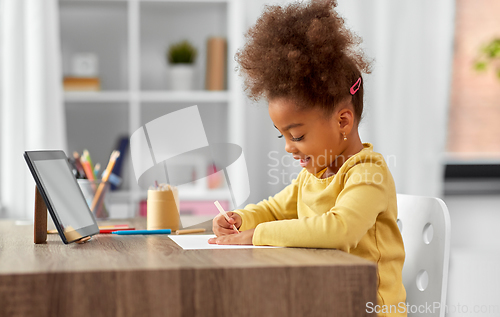 Image of little girl drawing with pencils at home