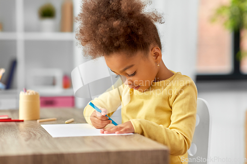 Image of little girl with felt pen drawing picture at home