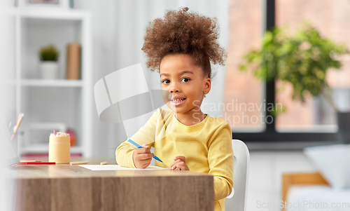 Image of little girl with felt pen drawing picture at home