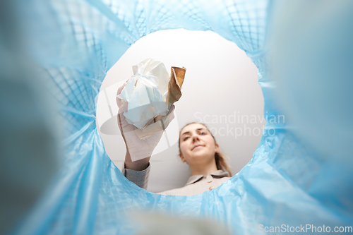 Image of hand throwing paper into trash can