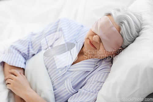 Image of senior woman with eye mask sleeping in bed at home