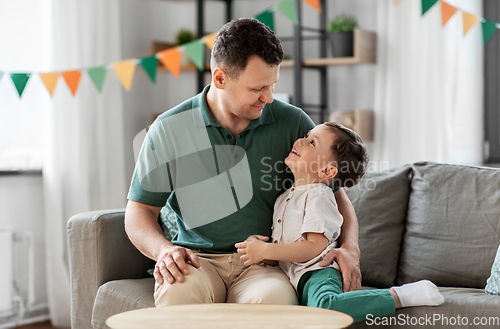 Image of happy father and little son at home birthday party