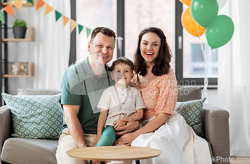 Image of happy family with little son at birthday party