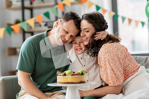 Image of happy family with birthday cake hugging at home