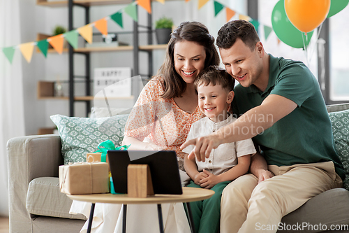 Image of happy family with tablet pc at home on birthday