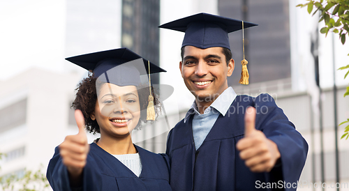 Image of happy students or bachelors showing thumbs up