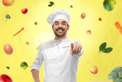 Image of happy smiling male chef in toque pointing to you