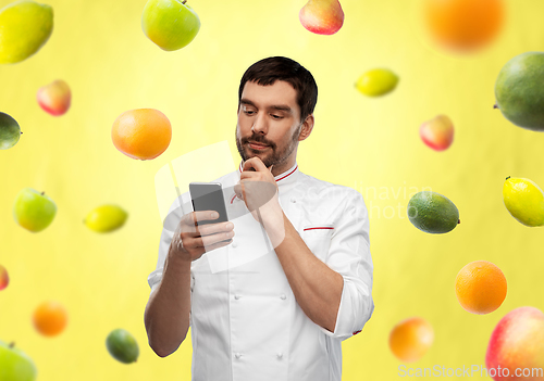 Image of thinking male chef with smartphone