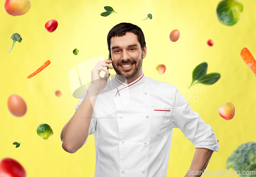 Image of happy smiling male chef calling on smartphone