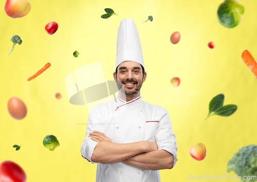 Image of happy smiling male chef in toque with crossed arms