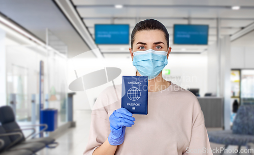 Image of woman in mask and gloves holding immunity passport