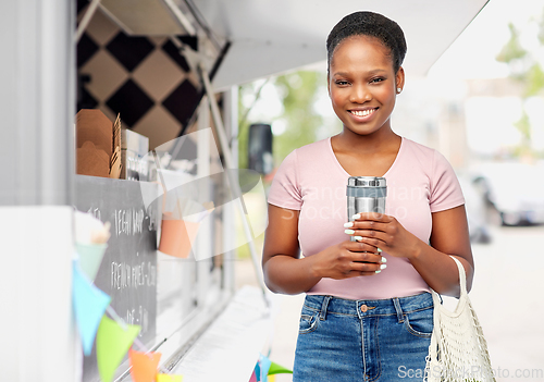 Image of woman with tumbler and string bag ober food truck