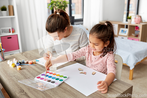 Image of mother with little daughter drawing at home