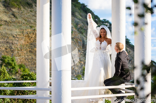 Image of Newlyweds on a walk in the gazebo look at each other happily