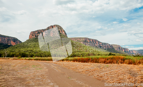 Image of Dirt road in Capertee Valley with rising rocky mountain in dista