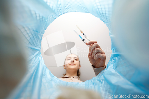 Image of woman throwing used syringes into trash can