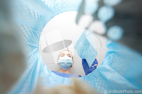 Image of doctor throwing used medical mask into trash can