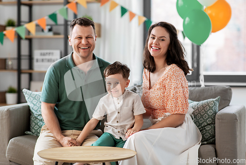 Image of happy family with little son at birthday party