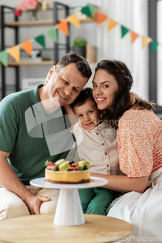 Image of happy family with birthday cake hugging at home