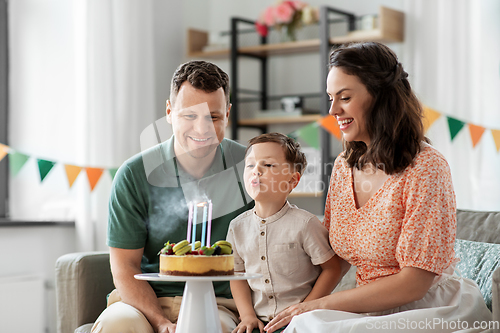 Image of happy family with birthday cake at home