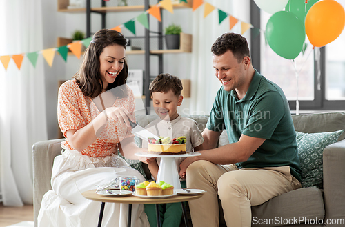 Image of happy family with birthday cake at home