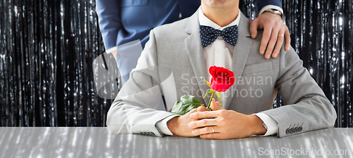 Image of close up of male gay couple with wedding rings on