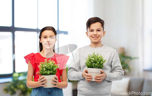 Image of happy smiling children holding flower in pot