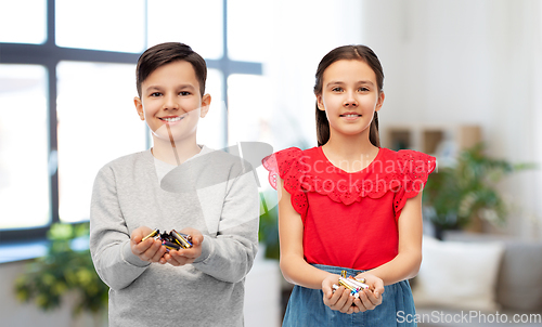 Image of smiling children holding alkaline batteries