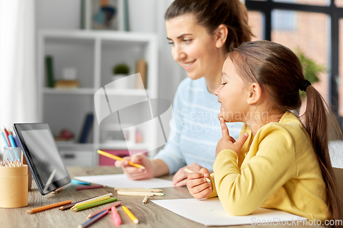 Image of mother and daughter with tablet pc drawing at home