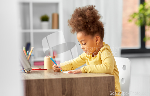 Image of little girl with felt pen drawing picture at home