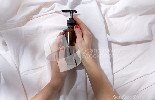 Image of hands with bottle of shower gel or liquid soap