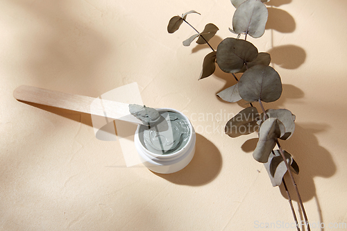 Image of cosmetic clay mask in jar with wooden spatula