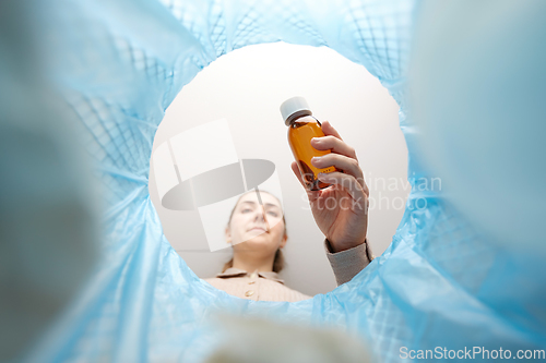 Image of woman throwing old medicine into trash can