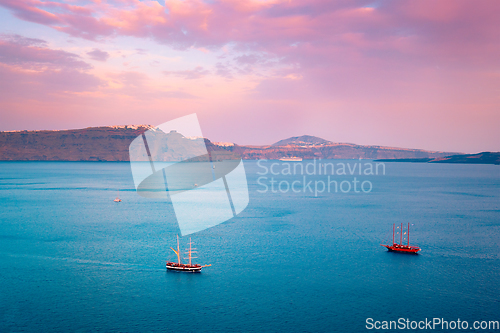 Image of Schooner vessel ship boat in Aegean sea near Santorini island with tourists going to sunset viewpoint