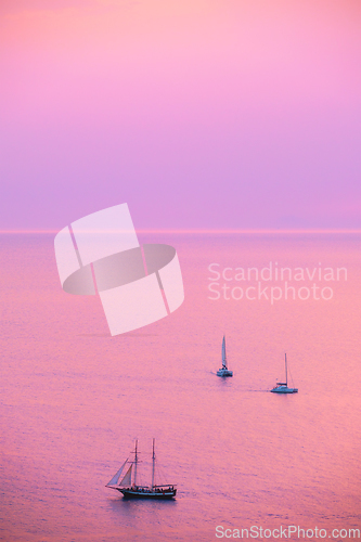 Image of Tourist yachts boat in Aegean sea near Santorini island with tourists watching sunset viewpoint. Santorini, Greece