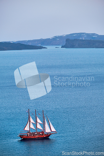 Image of Schooner vessel ship boat in Aegean sea near Santorini island with tourists going to sunset viewpoint