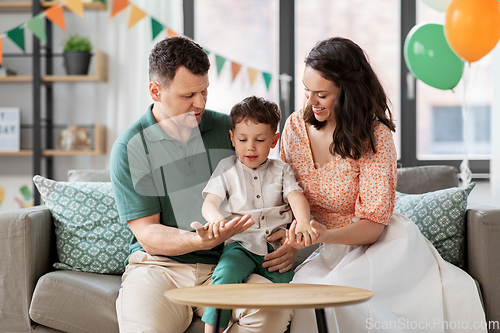 Image of happy family with little son at birthday party