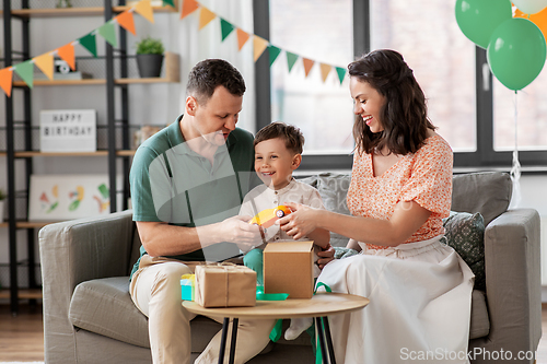 Image of happy family opening birthday presents at home