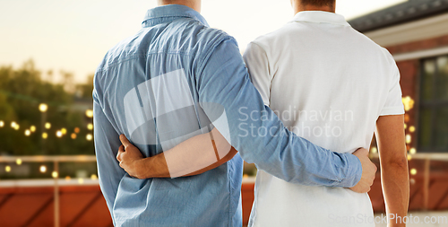 Image of close up of happy male gay couple hugging at party