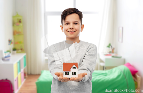 Image of smiling boy holding house model