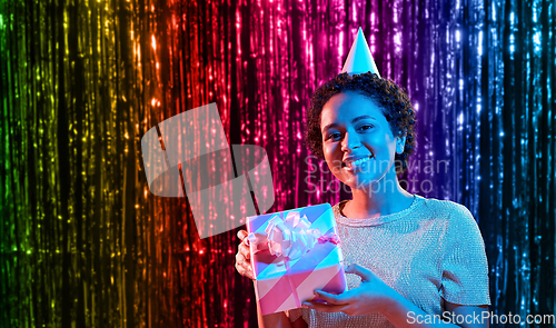 Image of african woman in party cap with gift box on black