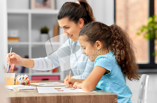 Image of happy mother with little daughter drawing at home