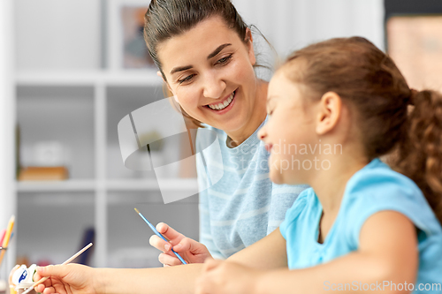 Image of mother with little daughter drawing at home