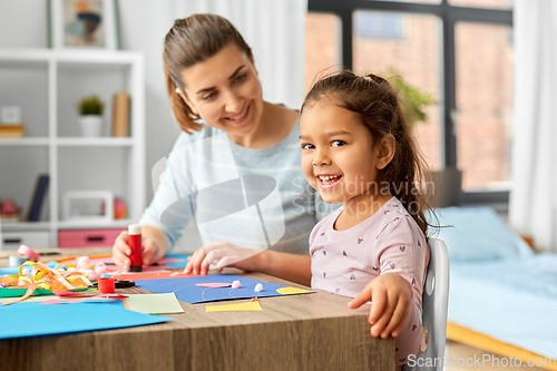 Image of daughter with mother making applique at home