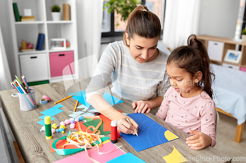 Image of daughter with mother making applique at home