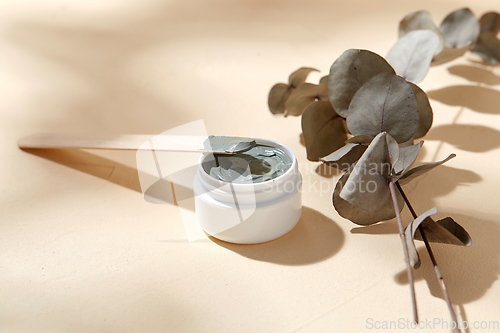 Image of cosmetic clay mask in jar with wooden spatula