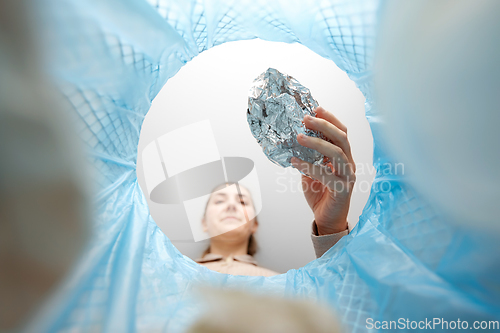 Image of woman throwing crumpled foil into trash can